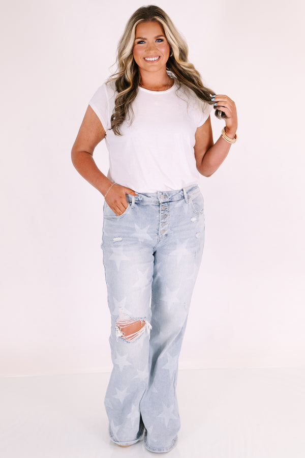 Plus Size light wash flare jeans with a white star pattern, button fly, and distressed knee.
