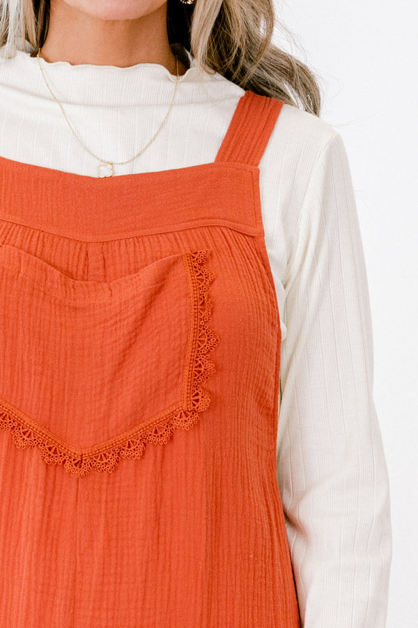 Chic Soul plus size clothing, rust colored sleeveless jumpsuit with two front pockets and a pocket on the chest that has fringe details 