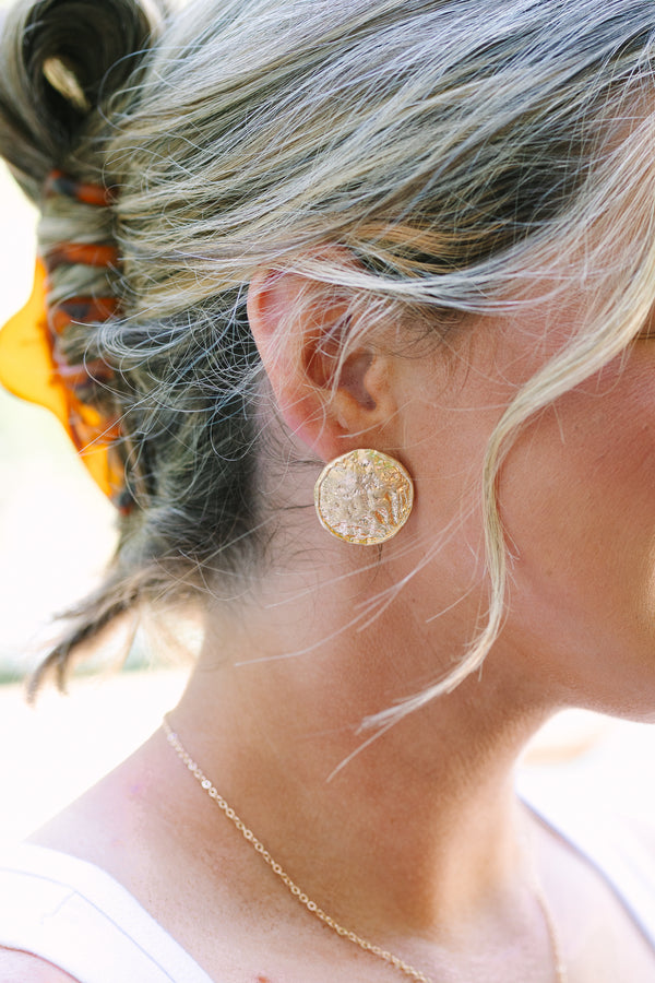 Textured gold round stud earrings with a hammered metallic finish.