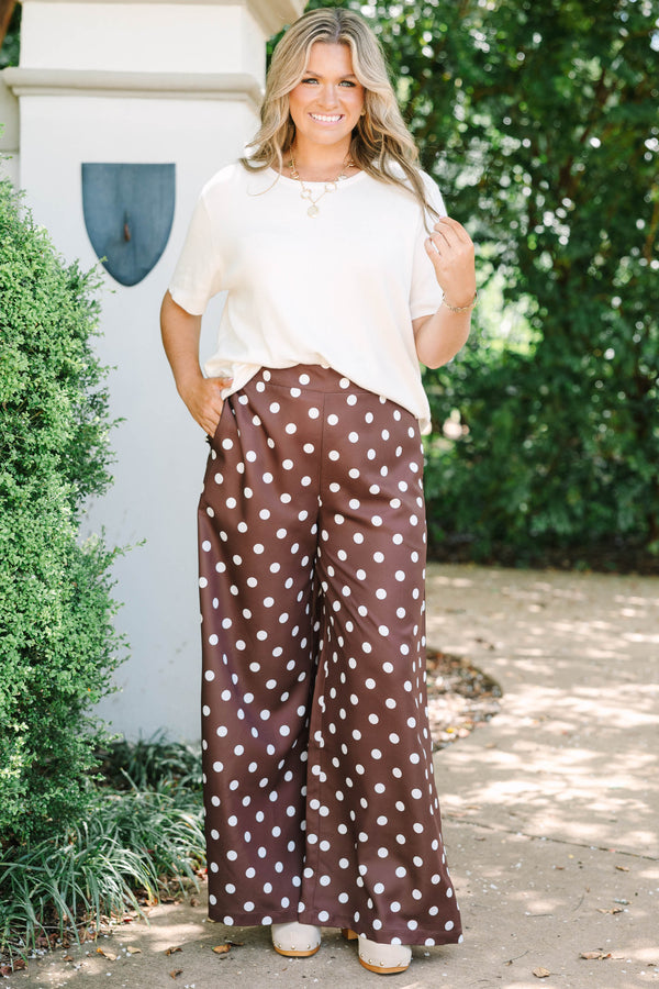 High-rise chocolate brown palazzo pants with white polka dots and a flowy wide-leg silhouette.