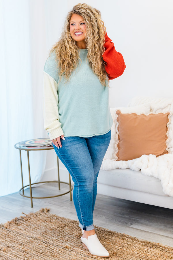 Chic Soul plus size clothing, long-sleeve knit blue sweater with one sleeve ivory and one sleeve rust orange with a scoop-neckline and inside-out stitching 
