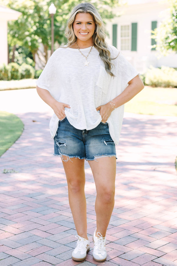 Plus Size dark wash denim shorts with distressing and a frayed raw hem.