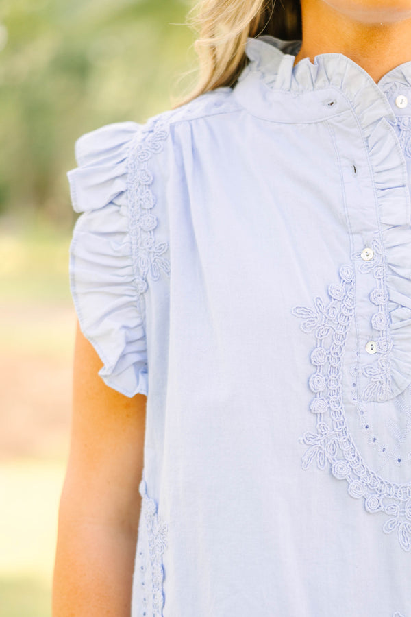 Plus Size light blue sleeveless top with ruffle trim, high neck, and intricate floral embroidery.
