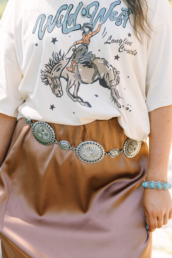 Plus Size silver concho chain belt with intricate sunburst engravings over a brown satin skirt.