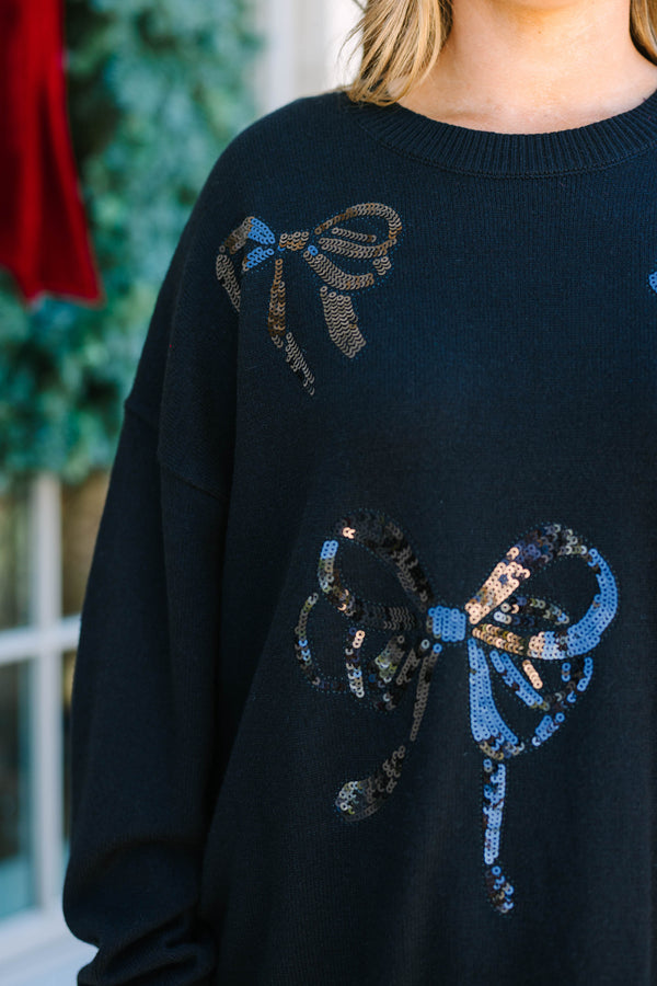 Plus Size black crewneck sweater with sequined bow patterns paired with a burgundy faux leather skirt.