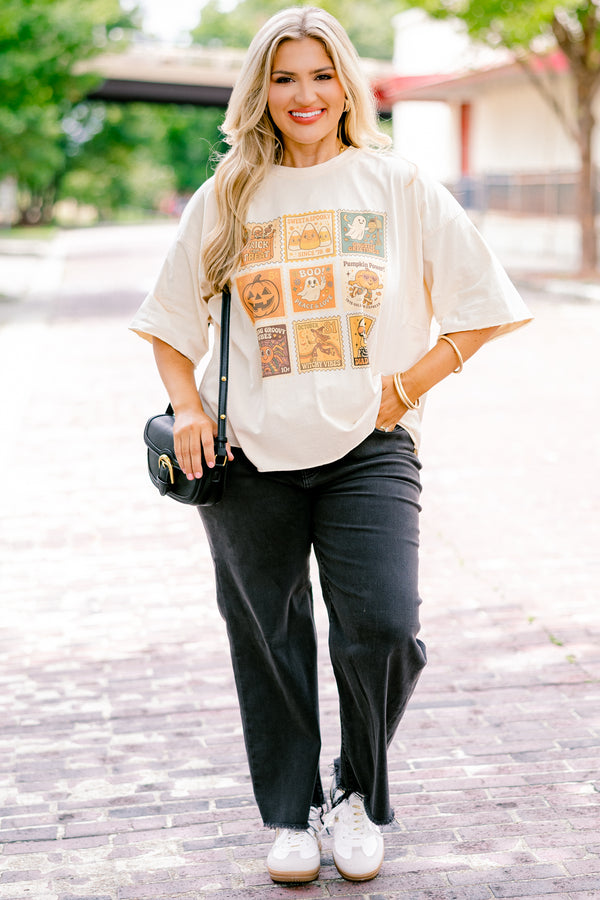 Chic Soul plus size clothing, off white, half sleeve boxy oversized tee with Halloween themed stamps on the front in shades of orange with designs like candy corn, ghosts, pumpkins, witches, and skulls