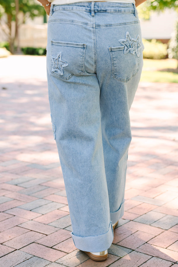Plus Size light wash wide leg jeans with dark blue star and heart patches and frayed star cutouts.