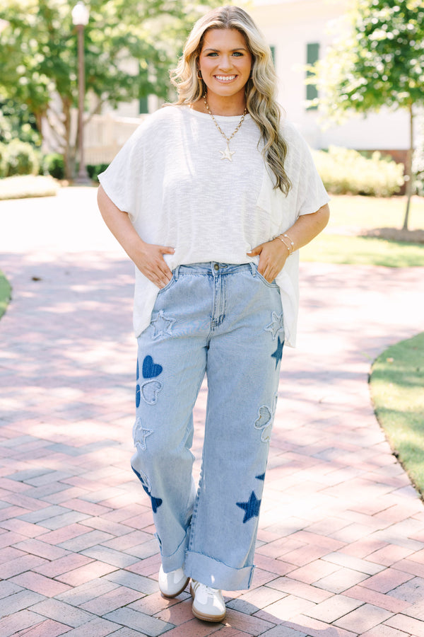 Plus Size light wash wide leg jeans with dark blue star and heart patches and frayed star cutouts.