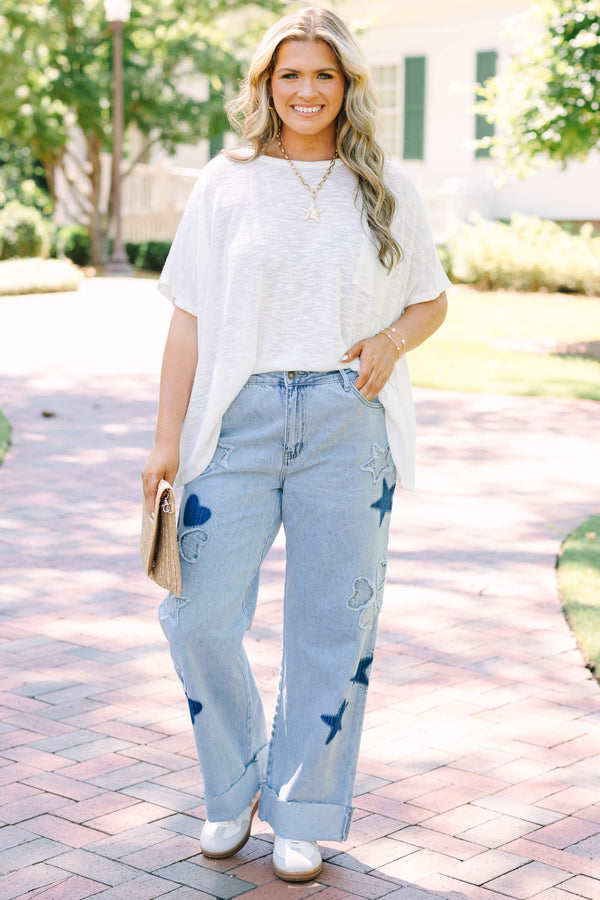 Plus Size light wash wide leg jeans with dark blue star and heart patches and frayed star cutouts.