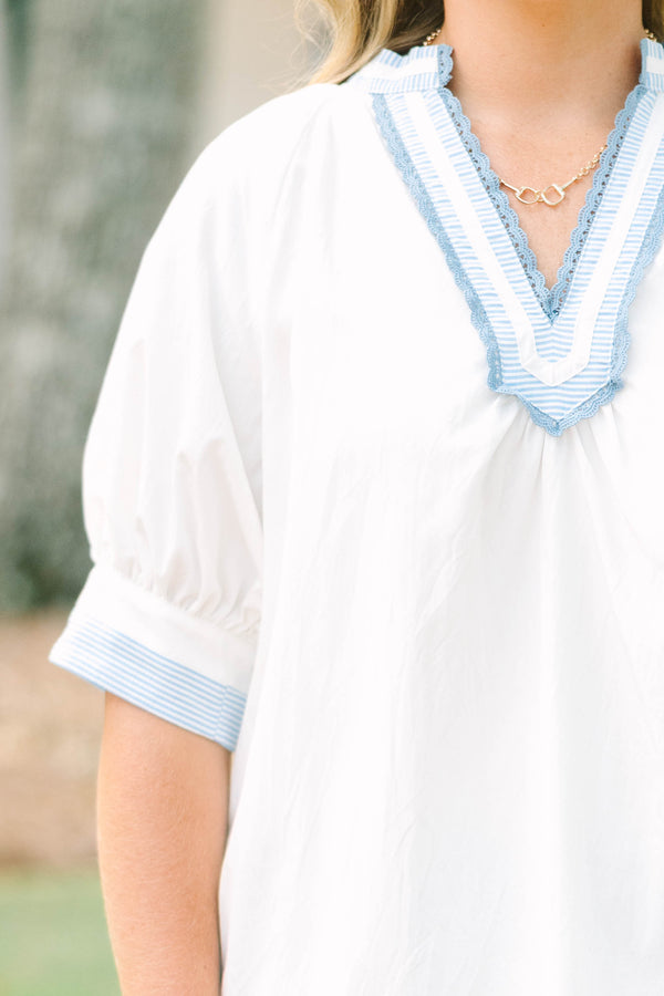 Plus Size white v-neck blouse with blue striped contrast trim, jacquard detail, and puff sleeves.