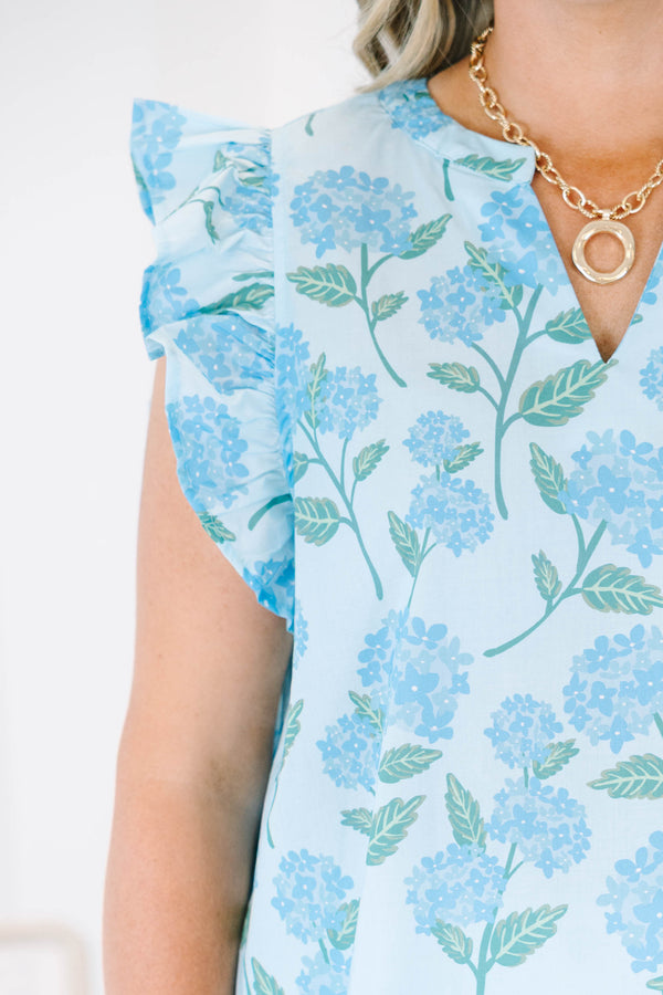 Plus Size light blue top with a floral hydrangea print, ruffle cap sleeves, and a split neckline.