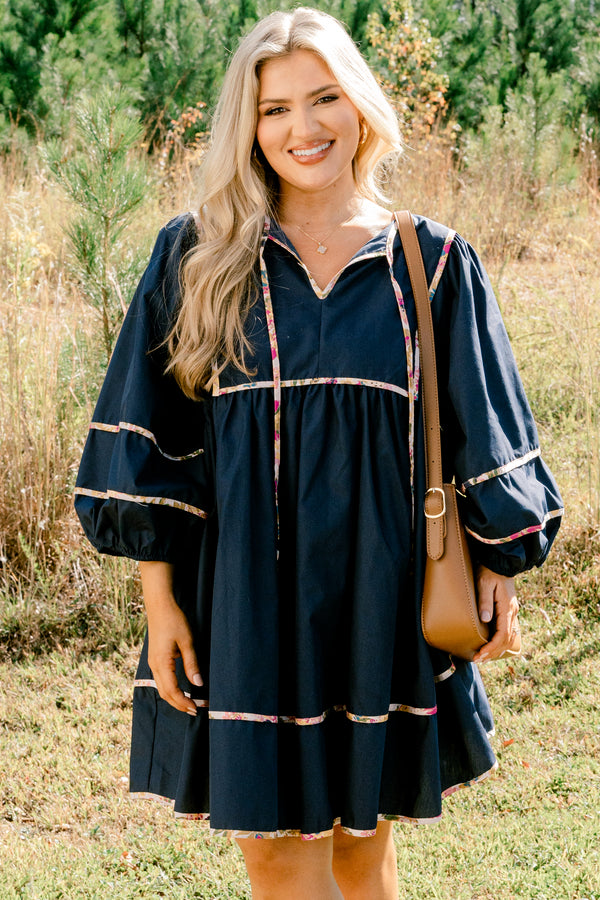 Chic Soul plus size clothing, navy long puff sleeve knee length dress with floral patterned detailing on the seams and tassels at the neckline