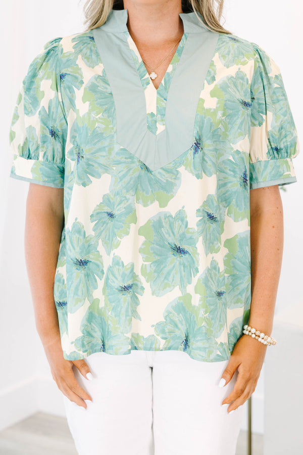 Plus size green floral print top with puff sleeves and a V-neckline.