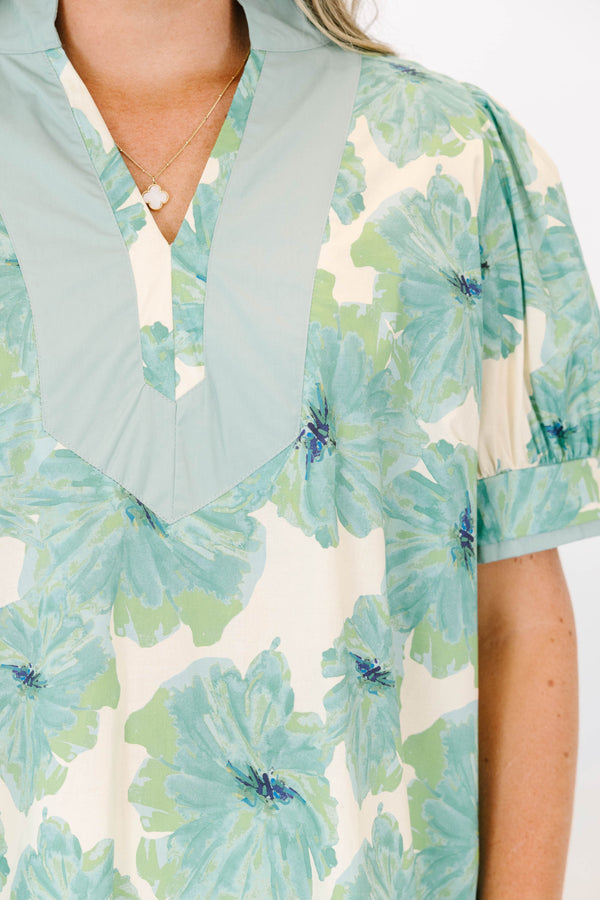 Plus size green floral print top with puff sleeves and a V-neckline.
