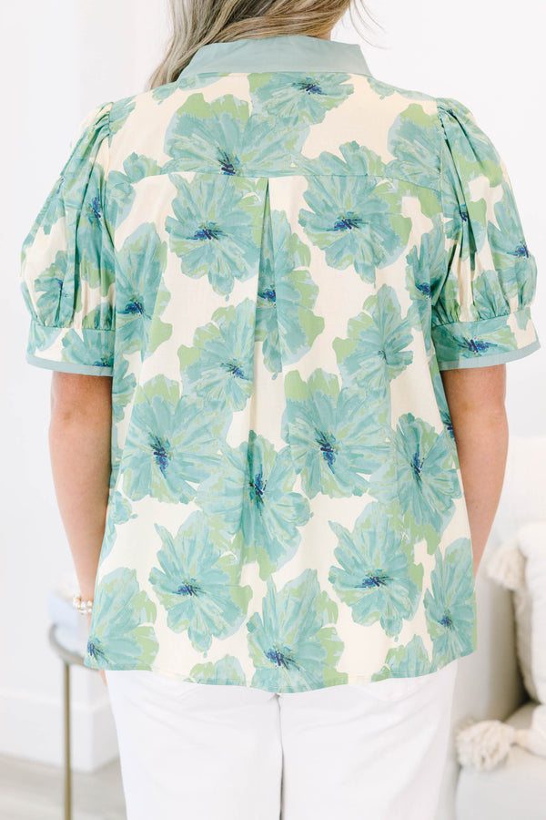 Plus size green floral print top with puff sleeves and a V-neckline.