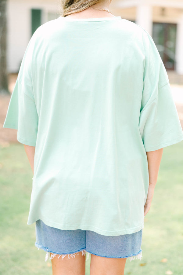 Plus size light sage boyfriend tee with 'Cool Moms Club' graphic and a relaxed, flowy fit.