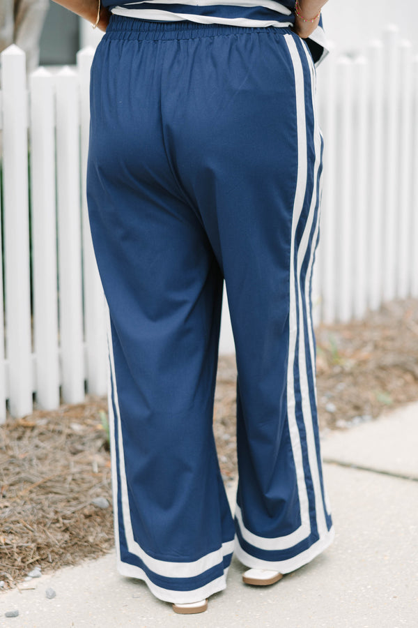 Chic Soul plus size clothing, navy blue long flowy pants with elastic waistband and drawstrings with vertical white lines down the outer sides of the pants that lead into horizontal white lines bordering the bottom of the pants