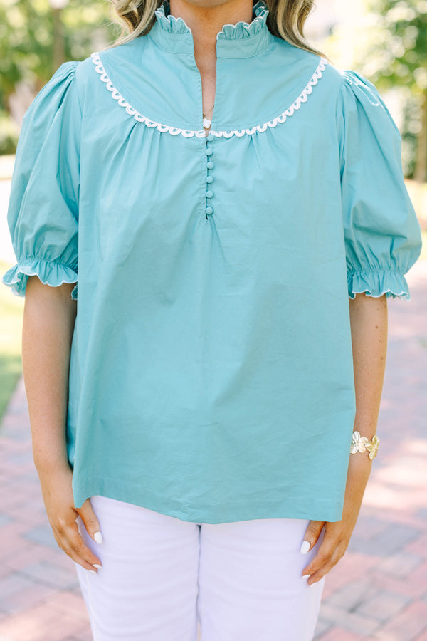 Plus Size green top with a ruffled high neck, white scalloped trim, and puff sleeves.