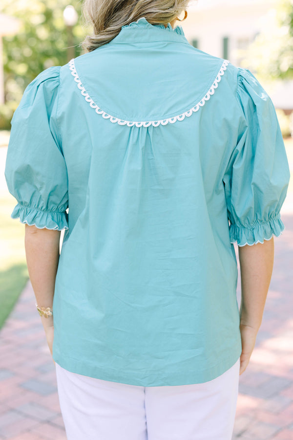 Plus Size green top with a ruffled high neck, white scalloped trim, and puff sleeves.