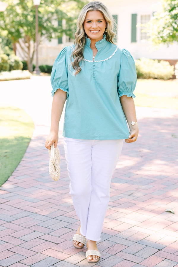Plus Size green top with a ruffled high neck, white scalloped trim, and puff sleeves.