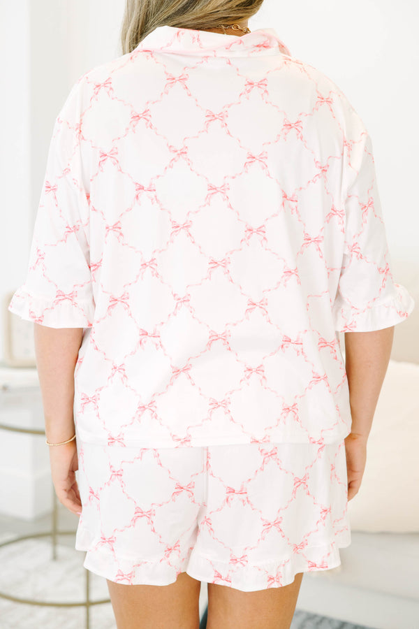 Plus Size white pajama set with pink bow print, featuring a tie-front top and ruffled shorts.
