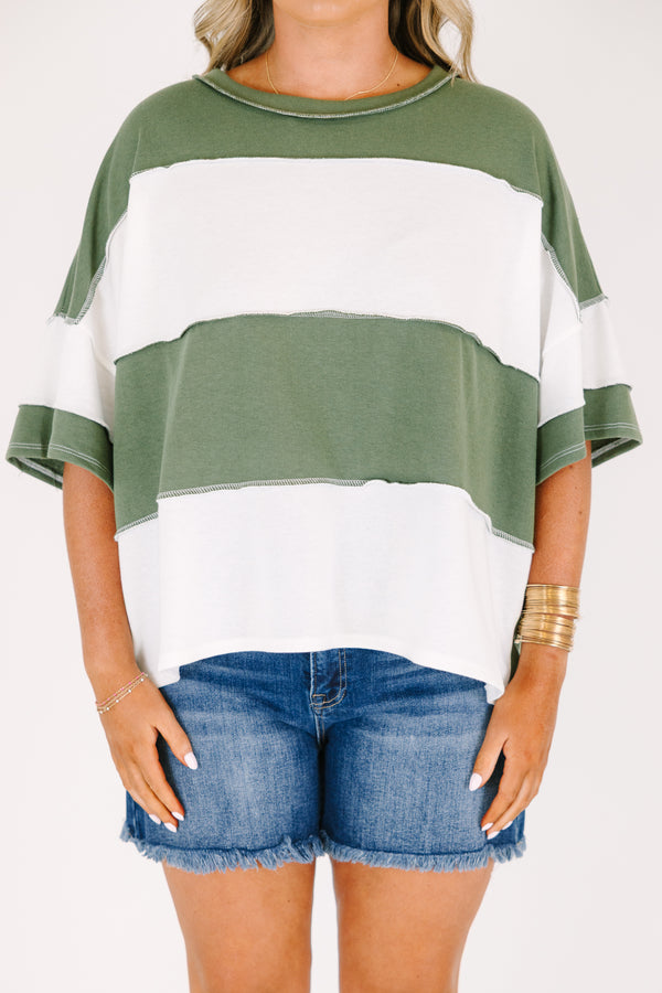 Plus size woman in a light olive and white striped oversized tee with raw edge seam details.