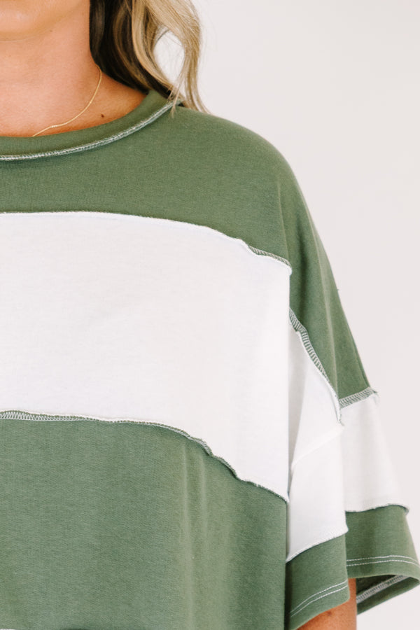 Plus size woman in a light olive and white striped oversized tee with raw edge seam details.