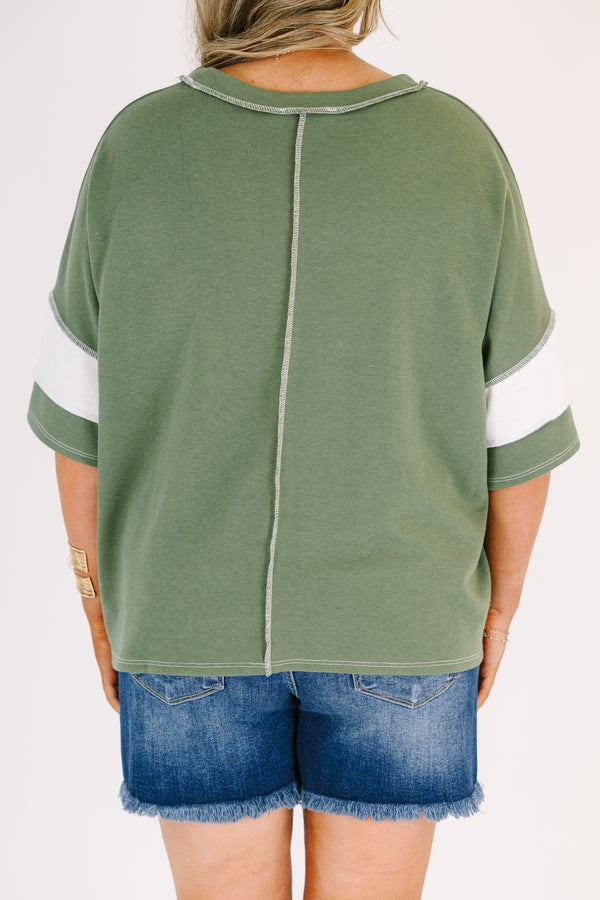 Plus size woman in a light olive and white striped oversized tee with raw edge seam details.