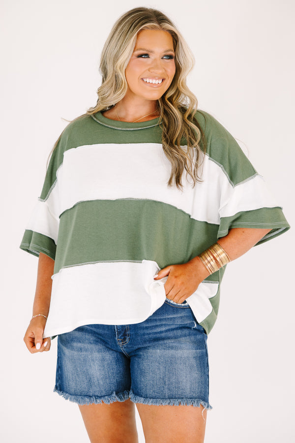 Plus size woman in a light olive and white striped oversized tee with raw edge seam details.