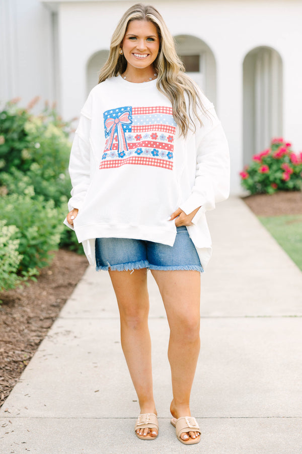 Plus Size ivory crew neck sweatshirt with a patriotic floral flag graphic and denim shorts.