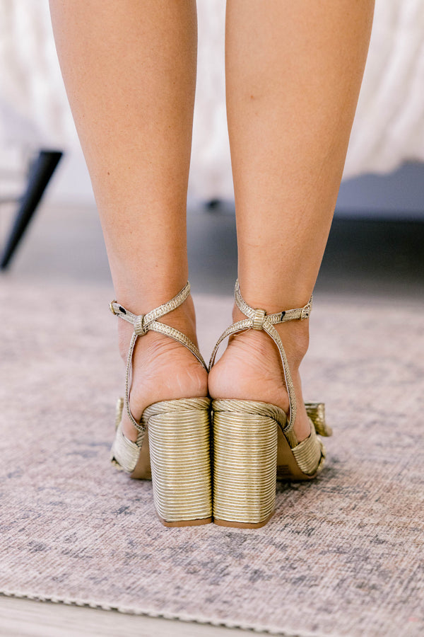 Chic Soul plus size clothing, gold heels with a strap around the ankle and a bow detail on the strap that goes across the foot 