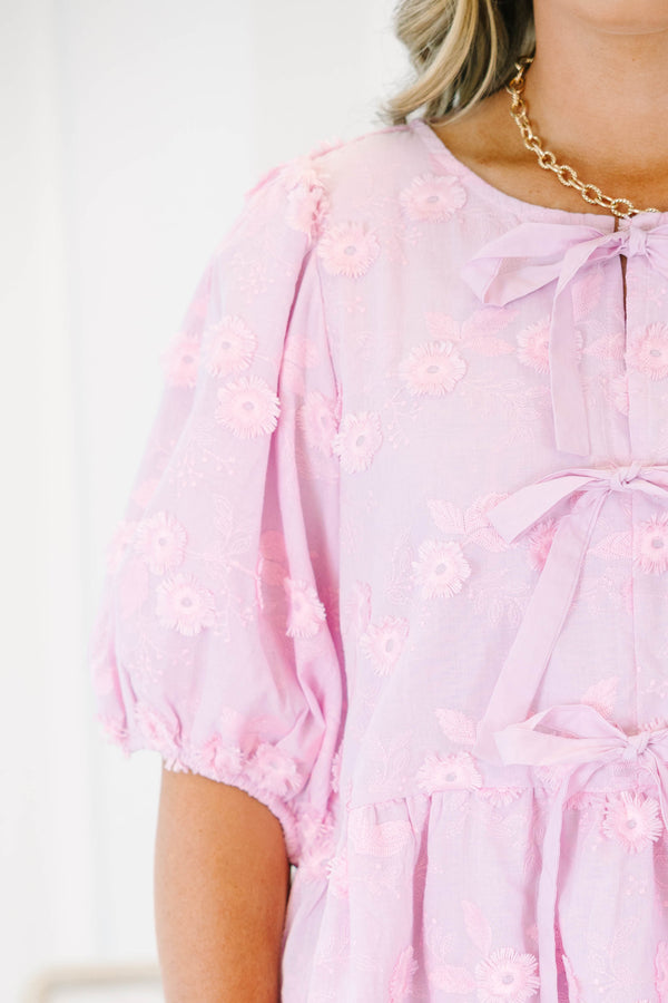 Plus Size pink eyelet top with puff sleeves, three front bow ties, and a peplum hem.