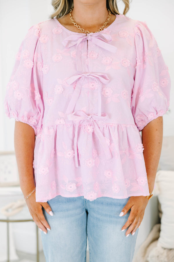 Plus Size pink eyelet top with puff sleeves, three front bow ties, and a peplum hem.