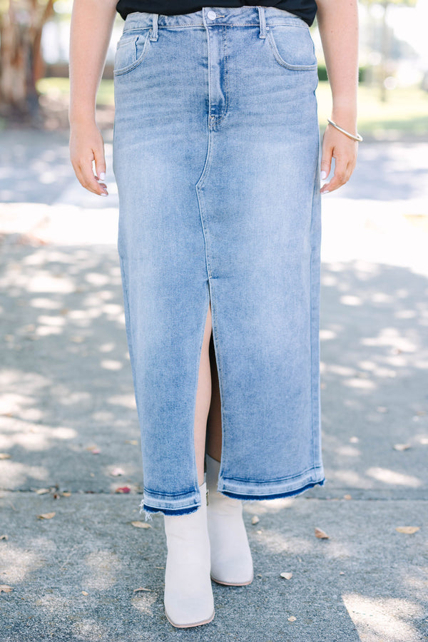Plus size medium wash denim midi skirt with a front slit and raw hem for a confident, chic look.