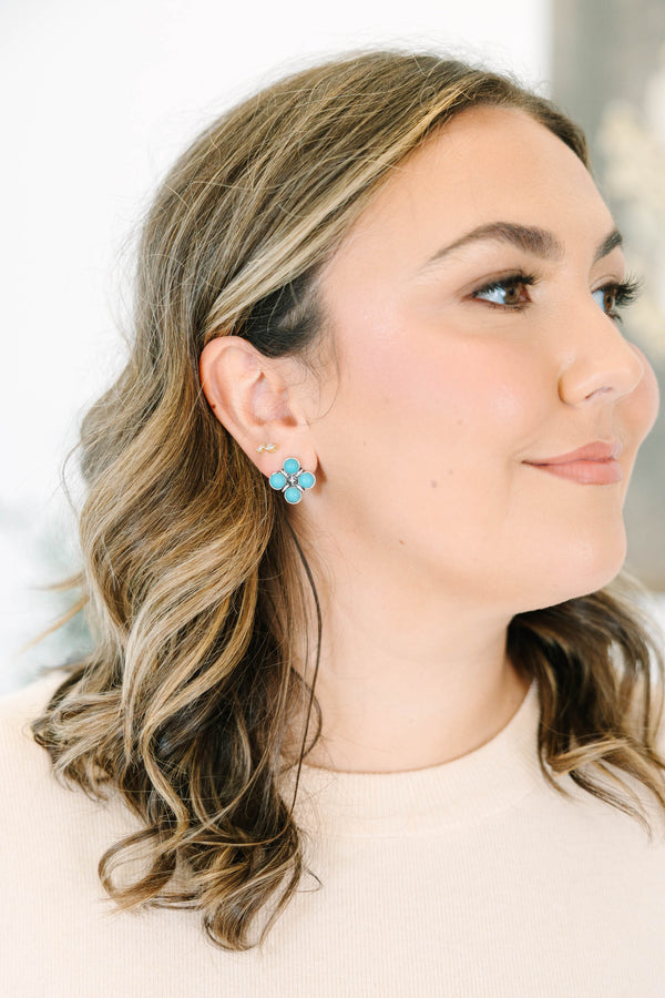 Close-up of a woman wearing The Darling Earrings, featuring four round turquoise stones in silver.