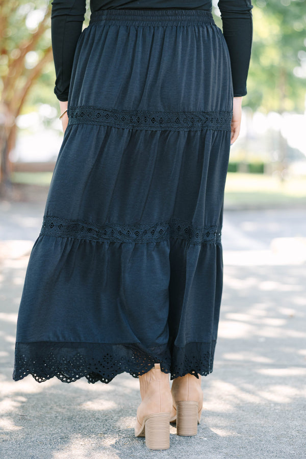 Plus size black tiered maxi skirt with lace trim, smocked waist, and flowy silhouette.