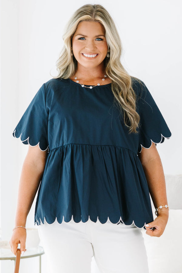 Plus size navy babydoll top with white scalloped trim on the sleeves and hem.