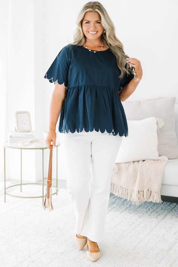 Plus size navy babydoll top with white scalloped trim on the sleeves and hem.