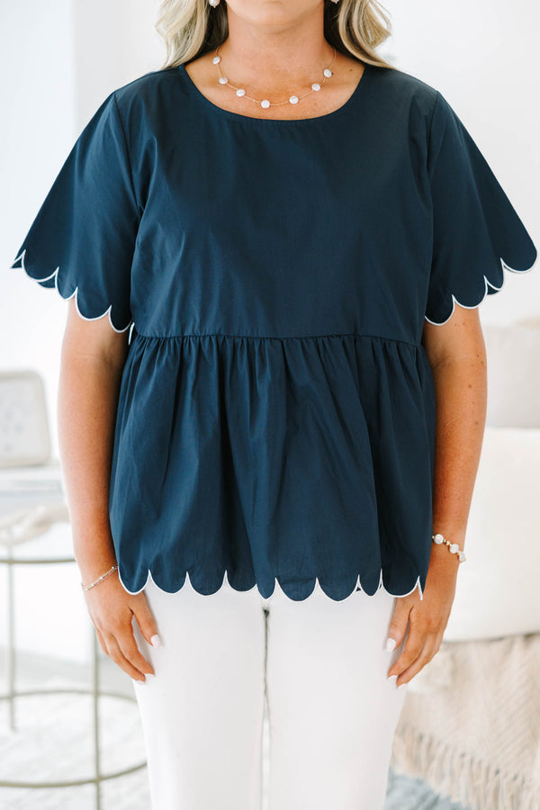 Plus size navy babydoll top with white scalloped trim on the sleeves and hem.