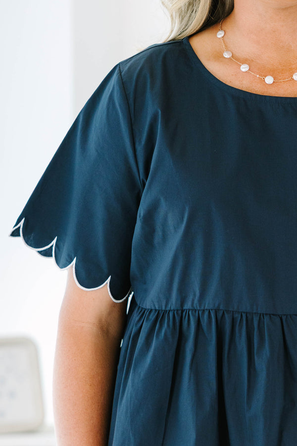 Plus size navy babydoll top with white scalloped trim on the sleeves and hem.