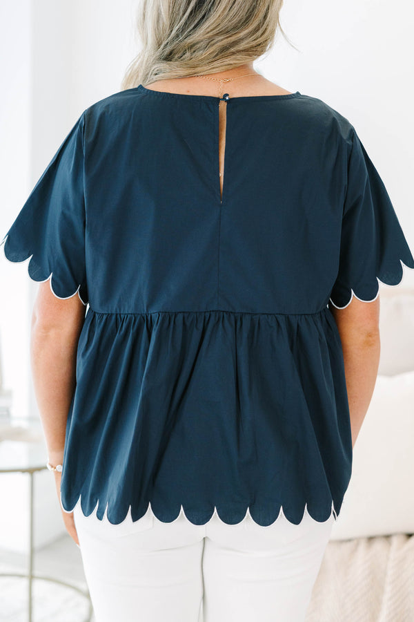 Plus size navy babydoll top with white scalloped trim on the sleeves and hem.