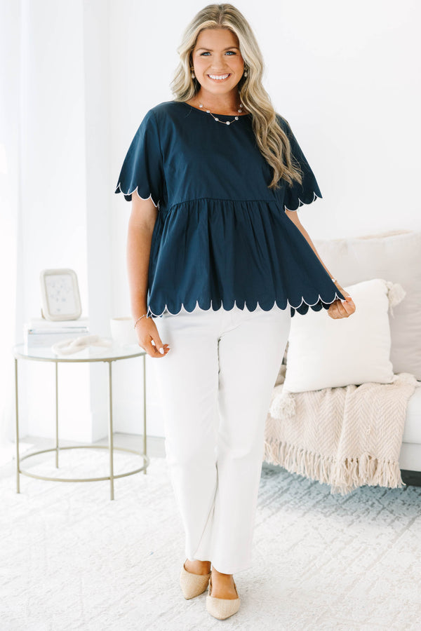 Plus size navy babydoll top with white scalloped trim on the sleeves and hem.