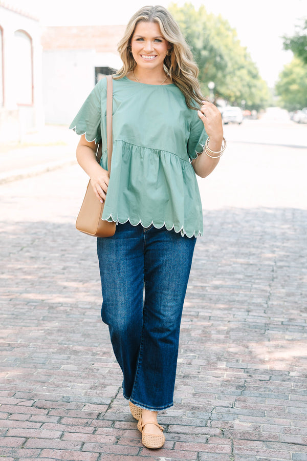 Plus Size olive babydoll top with white scalloped trim on the sleeves and hem.