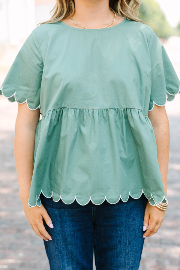 Plus Size olive babydoll top with white scalloped trim on the sleeves and hem.