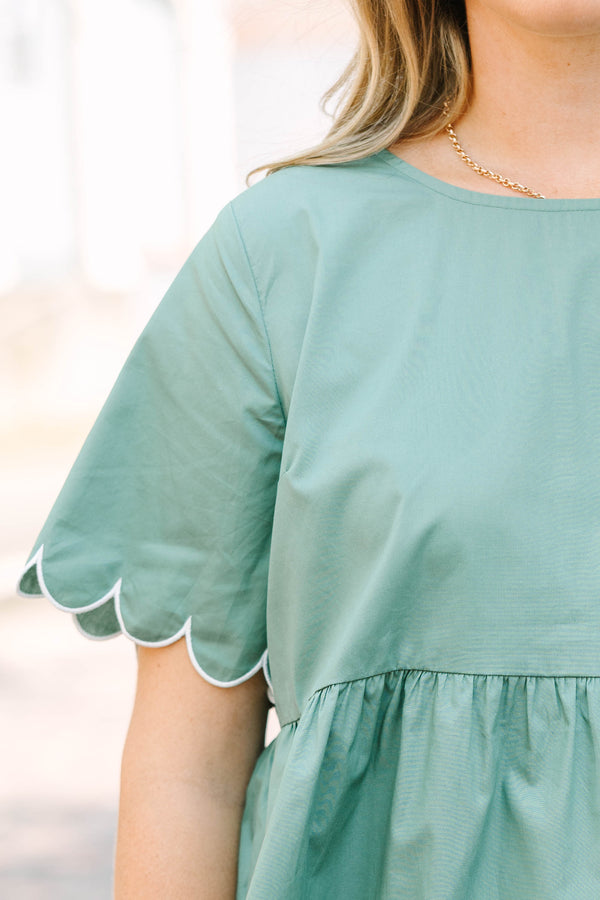 Plus Size olive babydoll top with white scalloped trim on the sleeves and hem.