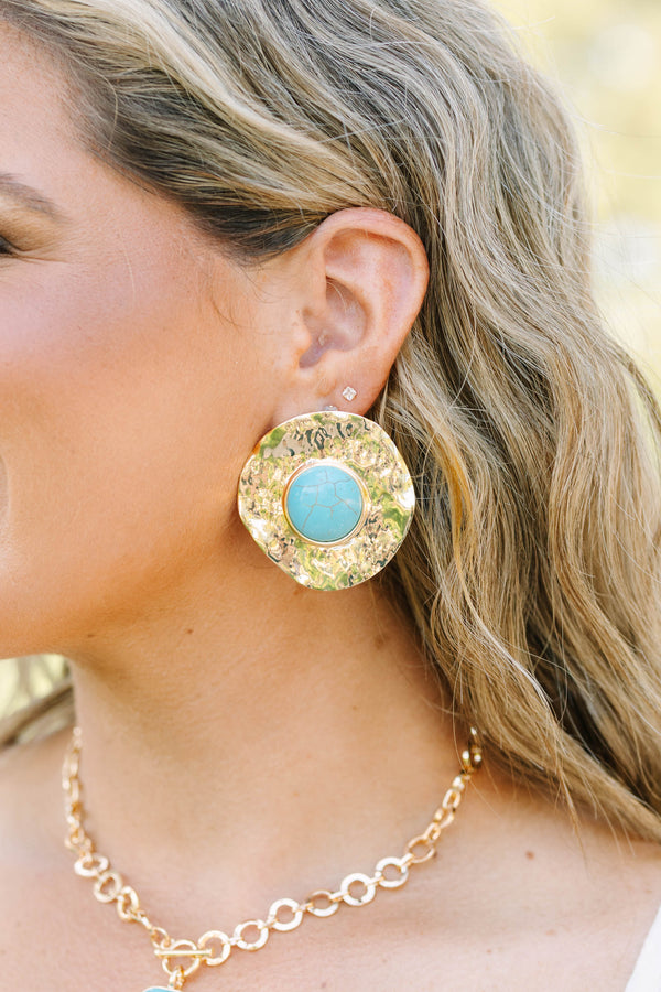 Large hammered gold disc earrings with a round turquoise stone center.
