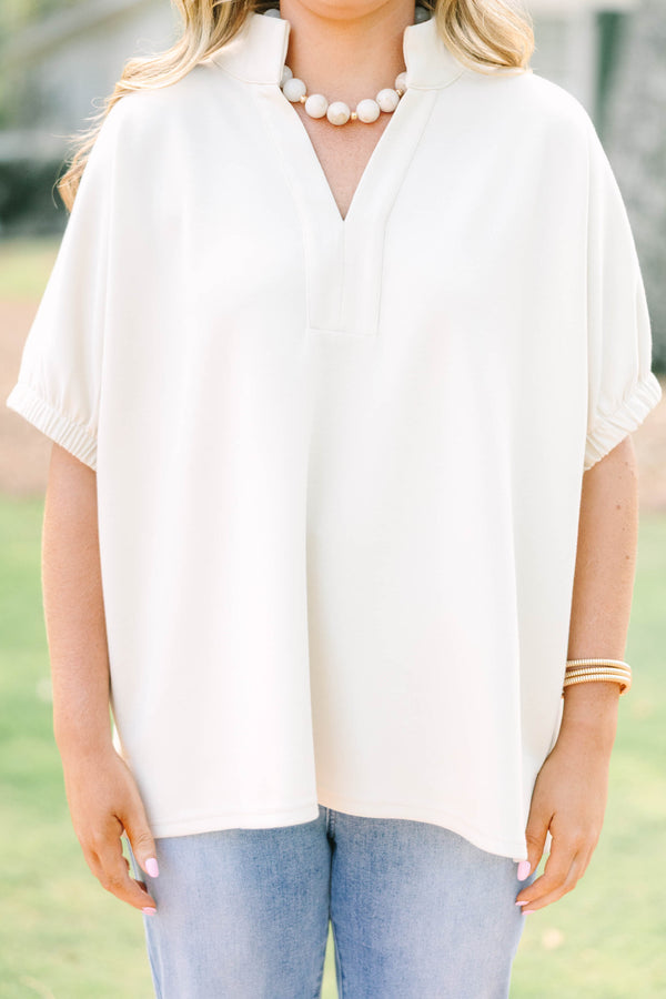 Plus Size beige short sleeve top with a V-neckline and elasticized puff sleeves.