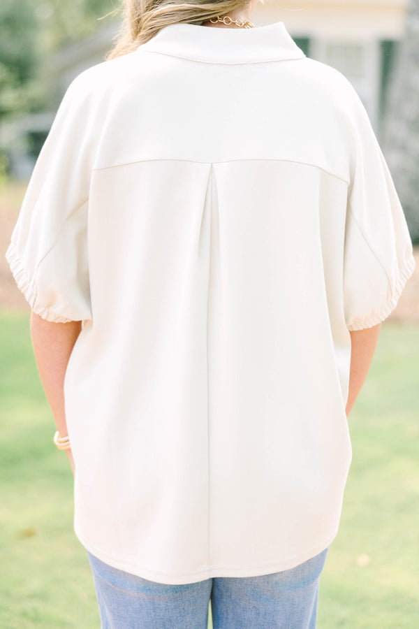 Plus Size beige short sleeve top with a V-neckline and elasticized puff sleeves.