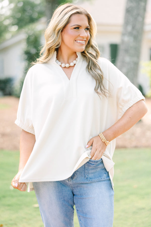 Plus Size beige short sleeve top with a V-neckline and elasticized puff sleeves.