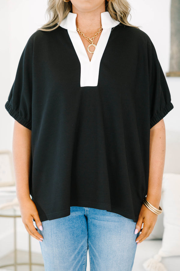 Plus size black top with a white v-neck collar, flowy fit, and short puff sleeves.